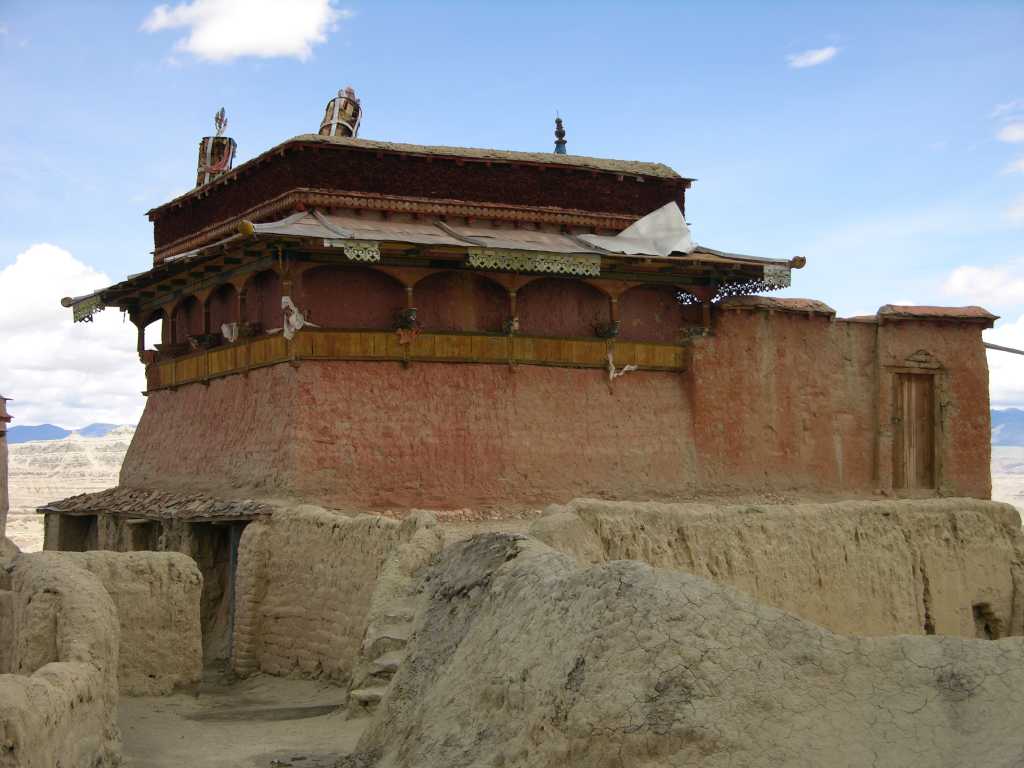Tibet Guge 09 Tsaparang Demchog Temple 01 Outside The Temple of Samvara/Bde-mchog is a chapel standing on top of the steep clayey mountain, around which the town was constructed, and around which was spread the crown of the caves of its inhabitants, dug out of the ravine. This small temple is built just in the middle of the royal palace. It was to host the tutelary spirit (yi-dam) of the country. - Giuseppe Tucci: The Temples of Western Tibet and their Artistic Symbolism (1935).